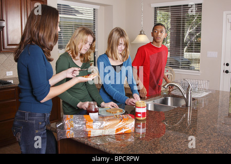 Teens making lunch, peanut butter and jelly sandwiches Stock Photo