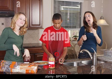 Teens making lunch, peanut butter and jelly sandwiches Stock Photo