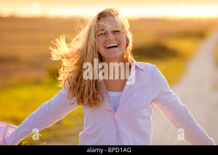 Young happy woman standing on country road Stock Photo
