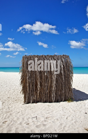Palapa Shelter on a White Sandy Caribbean Beach with a Blue Sky and White Clouds Stock Photo