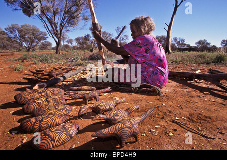 Senior Anangu woman preparing wood for carving, South Australia Stock Photo