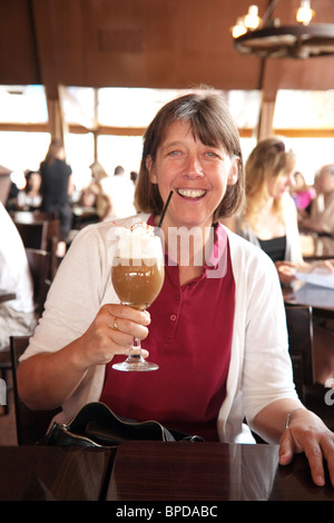 An attractive caucasian middle aged lady enjoys a liquor coffee, Mt Charleston Lodge Nevada, USA Stock Photo