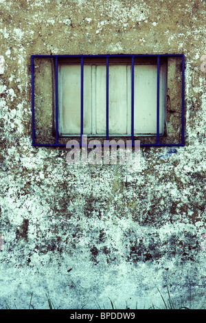 Barred window in gray wall Stock Photo