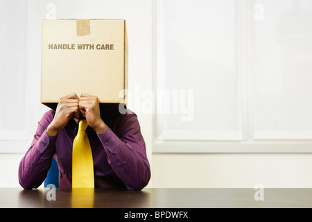Black businessman with box over his head