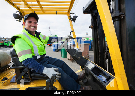 Hispanic man driving forklift Stock Photo