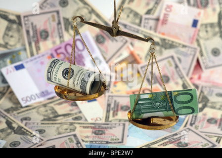 Unbalanced scales with dollar and euro banknotes Stock Photo
