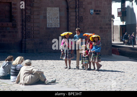 Tourists have their photos taken with traditionally dressed Peruvian people at the Plaza de Armas, Cusco, Peru. Stock Photo