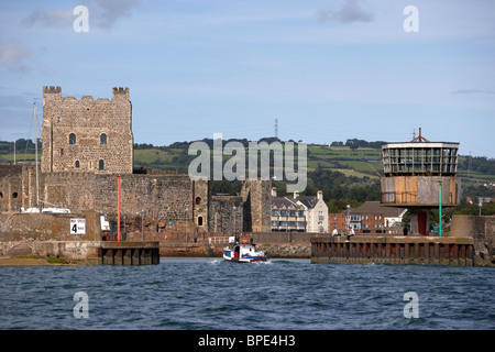 boat entering carrick harbour approaching carrickfergus castle county antrim northern ireland uk viewed from the sea Stock Photo