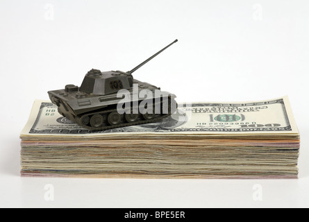 A model tank on a wad of 100-dollar notes Stock Photo