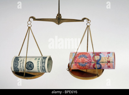 Dollar and renminbi yuan banknotes on balanced scales Stock Photo