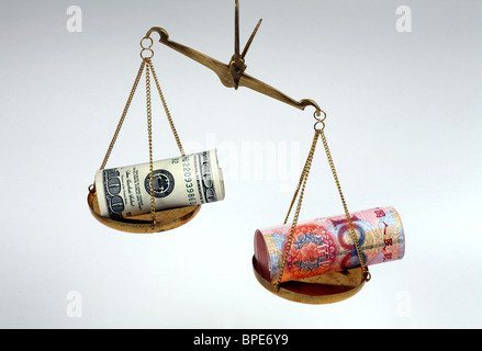 Dollar and renminbi yuan banknotes on scales Stock Photo