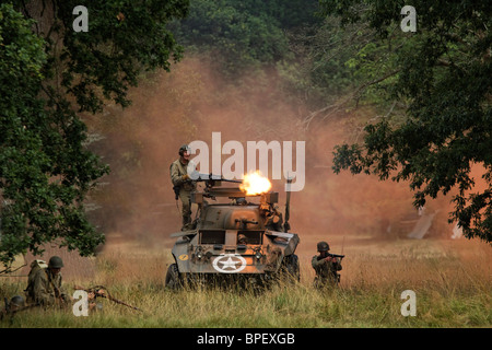 Ford Armored Car M8 Greyhound. Turret mounted 50 calibre machine gun - firing. Accompanied by light infantry. Orange flare smoke Stock Photo