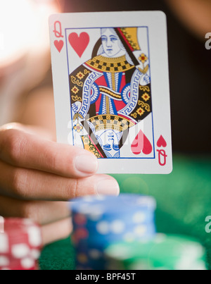 Hand holding queen of hearts playing card Stock Photo