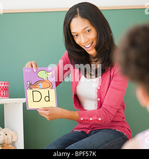 Black teacher showing letter d flash card to student Stock Photo