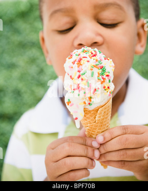 African American boy eating ice cream cone Stock Photo