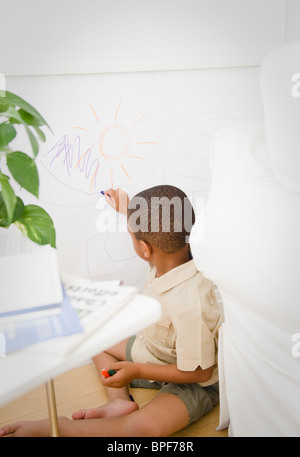 African American boy writing on white board Stock Photo - Alamy