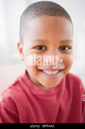 Vertical of smiling african american boy raising hand in elementary ...