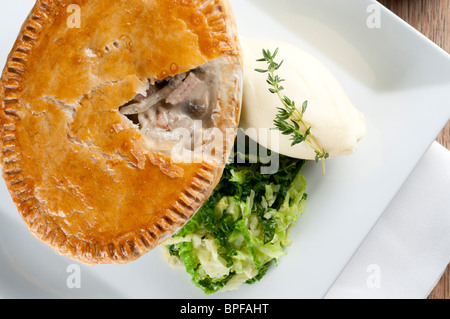 Traditional british pub food - big pie with mash and vegetables Stock Photo