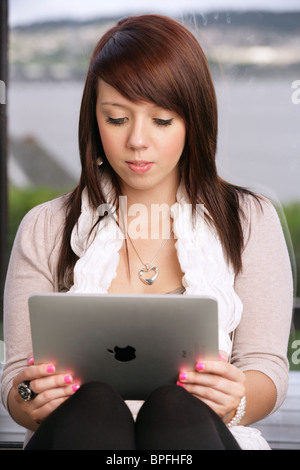 Woman holding an iPad in her hands at home. Stock Photo