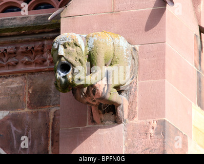 Gargoyle in the form of a seated man vomiting, on Freiburg Münster, Freiburg im Breisgau, Baden Wurtemburg, Germany Stock Photo