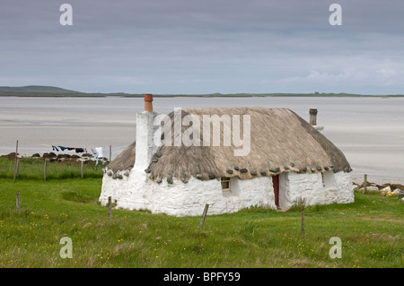 Traditional thatched cottage at Sollas overlooking Vallay Strand, North Uist, Hebrides, Western Isles, Scotland. SCO 6451 Stock Photo