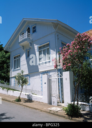 Traditional white painted Turkish townhouse with small balcony and pink bougainvillea growing on wall Stock Photo