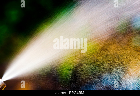 water spray burst - small water pieces creating rainbow colors in direct sunlight Stock Photo