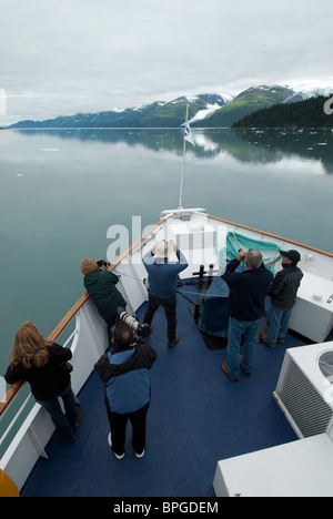 Folks search for wildlife from the bow, College Fjord, Cruise West Spirit of Columbia, Prince William Sound, Alaska. Stock Photo