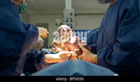 Baby being born via Caesarean Section coming out Stock Photo