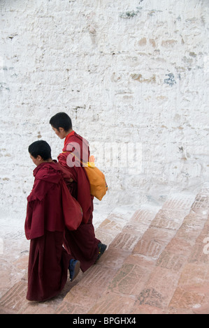 Tibet, Lhasa, 2 monks walking down steps  of Potala Palace Stock Photo