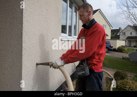 Man filling cavity wall with insulation Stock Photo