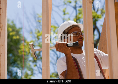 Carpenter using framing hammer on a house frame Stock Photo