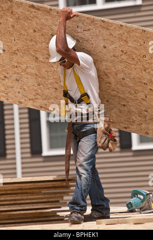 Carpenter carrying a particle board Stock Photo
