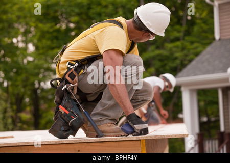 Carpenters laying a snap line on a particle board using chalk line Stock Photo