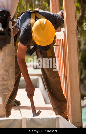 Carpenters using claw hammer at a construction site Stock Photo