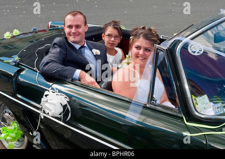 Bride and groom leaving for reception in Renault Caravelle convertible classic car - Indre-et-Loire, France. Stock Photo