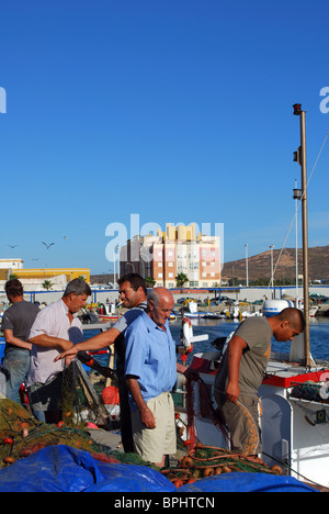 Fishermen tending to their nets in the harbour, Puerto de la Atunara, Costa del Sol, Cadiz Province, Andalucia, Spain, Europe. Stock Photo