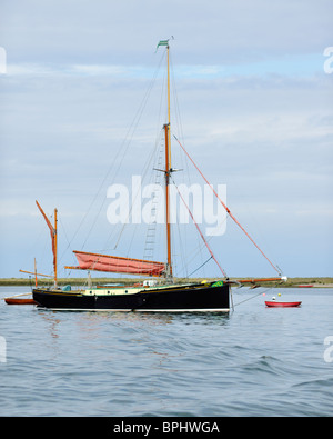 Imposing presence of a Thames barge anchored near Blakeney Point, Norfolk, England Stock Photo