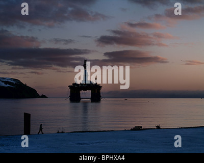 The Transocean Rather, a semi-submersible oil drilling rig, is silhouetted against the dawn, Cromarty Firth, Scotland Stock Photo