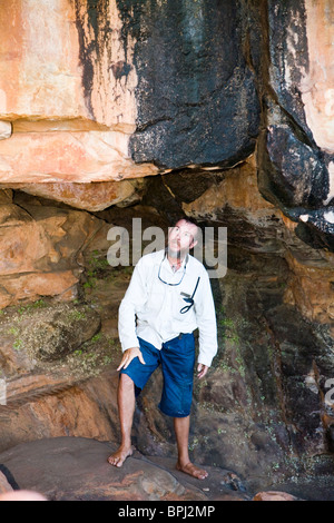 Orion Expedition team naturalist Harry Christiansen looks at Aboriginal rock art Raft Point Collier Bay Kimberley Australia Stock Photo