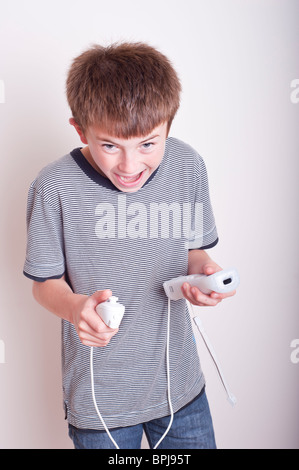 A MODEL RELEASED picture of a 10 year old boy playing with a Nintendo Wii remote and numchuck in the studio Stock Photo