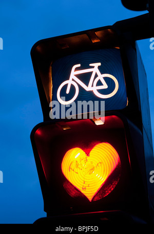 Detail of red cycle traffic stop light painted with love heart in Berlin Germany Stock Photo