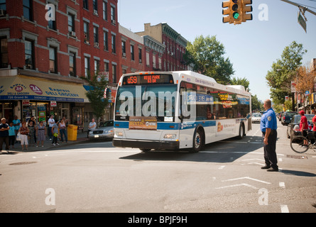 A NYC Transit bus travels through an intersection in the Williamsburg neighborhood of Brooklyn in New York Stock Photo