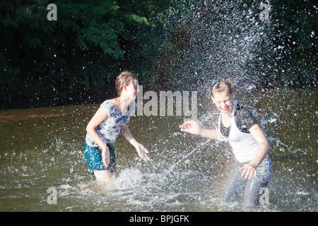 Young sisters playing in a river in summer. Stock Photo