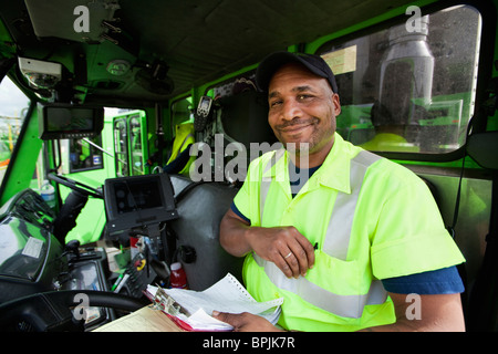 African American man driving garbage truck Stock Photo