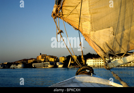 Felucca cruising the river Nile at sunset in Aswan in Upper Egypt. Stock Photo