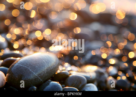 Background with sea stones and orange blurred circles. Stock Photo