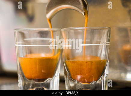 Close-up of espresso machine and shot glasses during a pour Stock Photo -  Alamy