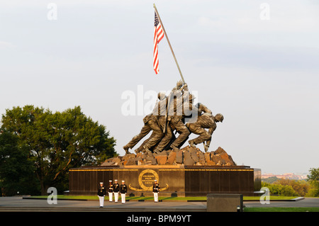 ARLINGTON, Virginia, United States — The Marine Corps Silent Drill Platoon performs at the Marine Corps Sunset Parade held at the Marine Corps War Memorial, also known as the Iwo Jima Memorial, located near Arlington National Cemetery. The platoon is renowned for its precision and discipline, showcasing the ceremonial skills of the US Marine Corps. Stock Photo