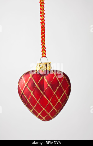 Red heart shaped Christmas ornament against white background Stock Photo